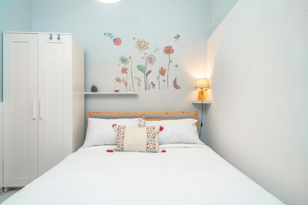 a bedroom with a white bed with flowers on the wall at Casa Idda in Linguaglossa