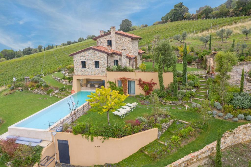 an external view of a villa with a swimming pool at Le Sughere in Riparbella