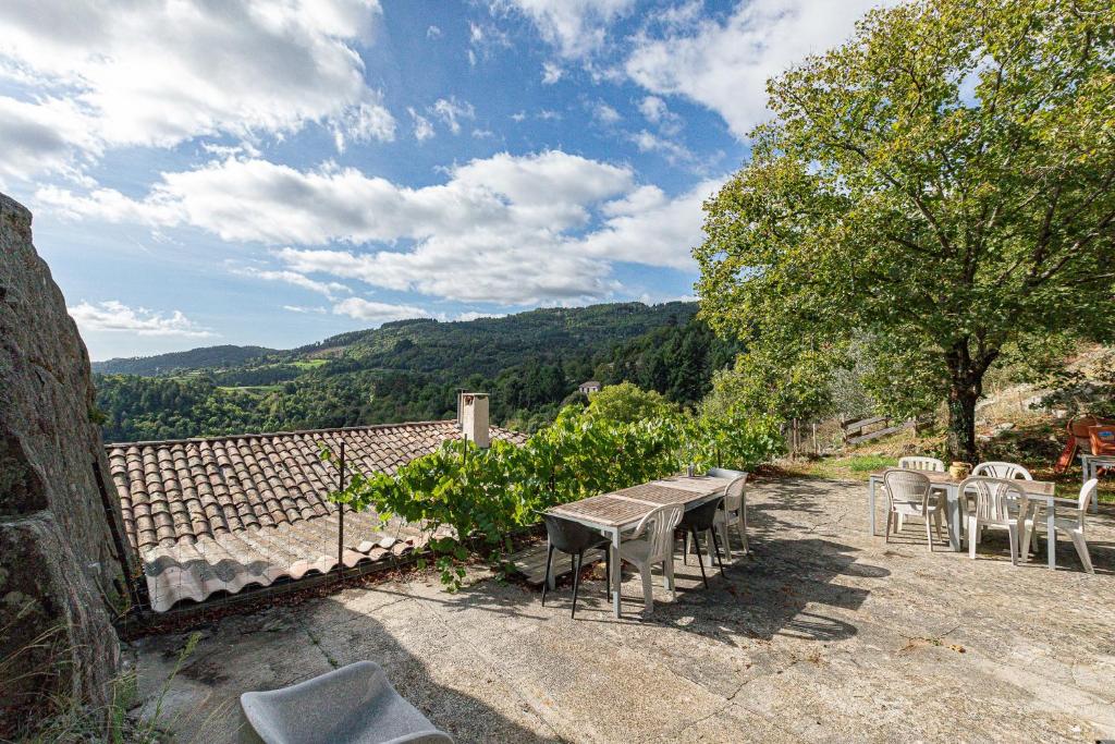 a table and chairs on a patio with a view at La Casita in Beauvène