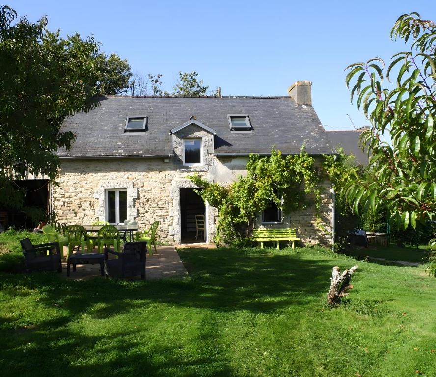an old stone house with a picnic table in the yard at Gîte Le Penn-ty in Rosporden