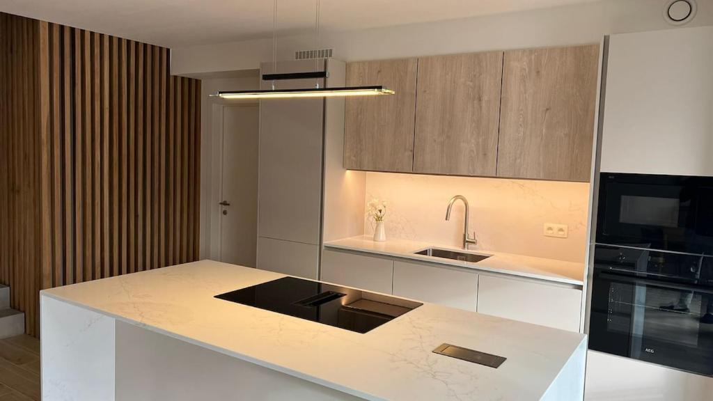 a kitchen with a white counter and a sink at Deluxe home garden and pool optional pm in Kortenberg