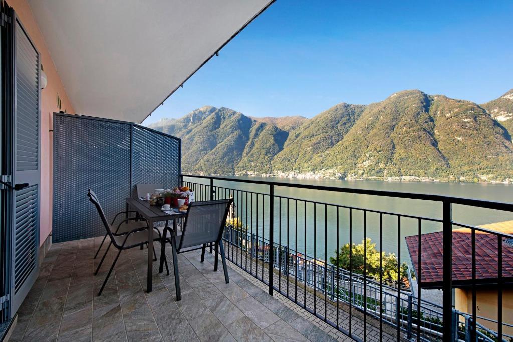 a balcony with a table and chairs and a view of the water at Appartamento 1 Il Tornante in Nesso