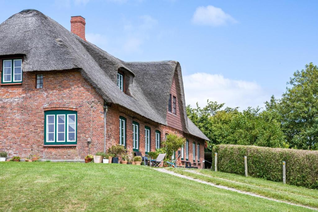 an old brick house with a thatched roof at Fewo Silbermöwe in Pellworm