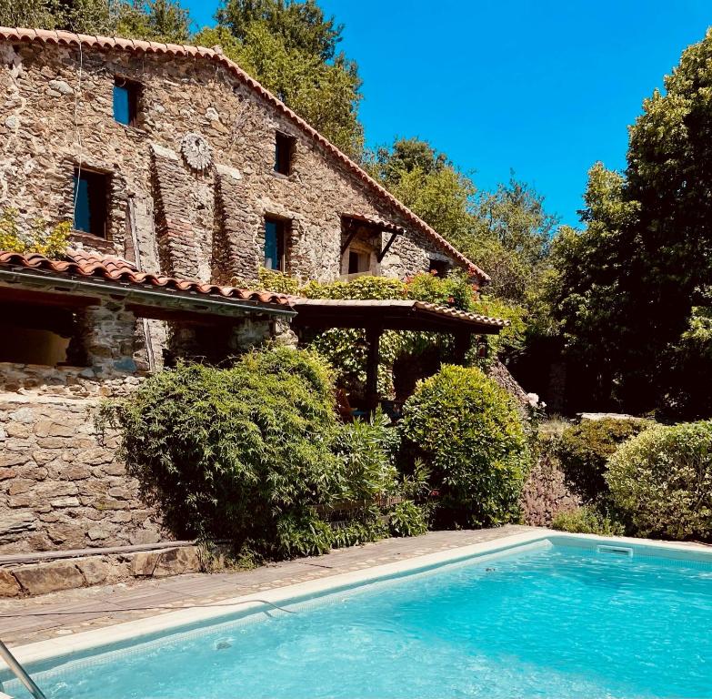 a house with a swimming pool in front of a building at Le Grand Mas de Can Noy in Montferrer