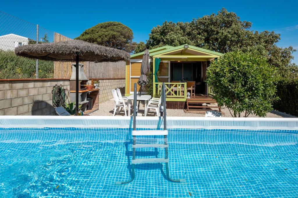 a house with a swimming pool with a table and an umbrella at La Breña in Barbate