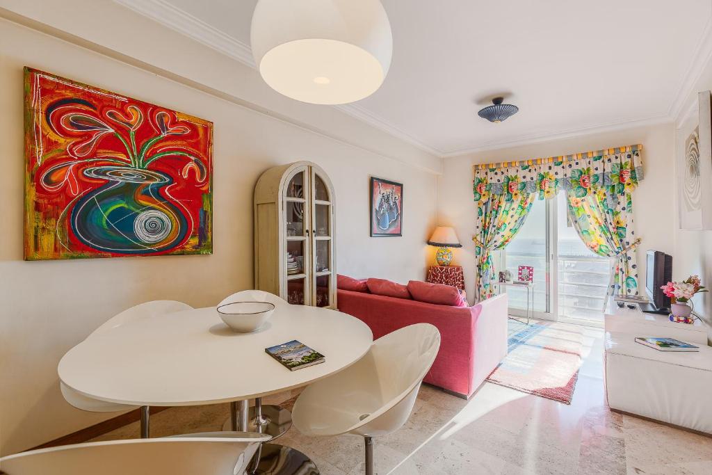 a living room with a white table and a pink couch at Setúbal Dreams in Setúbal