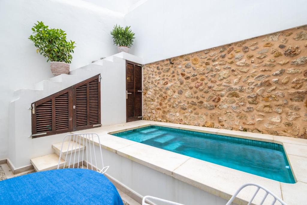 a swimming pool in a house with a stone wall at Casa La Roca in Pollença