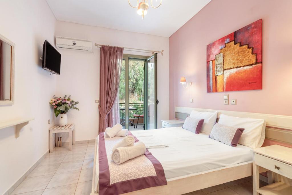 a bedroom with a large bed and a tv at Nontas Home 25 in Kalamitsi