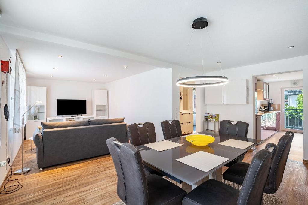 a dining room and living room with a table and chairs at Zum alten Wald in Zell am Harmersbach