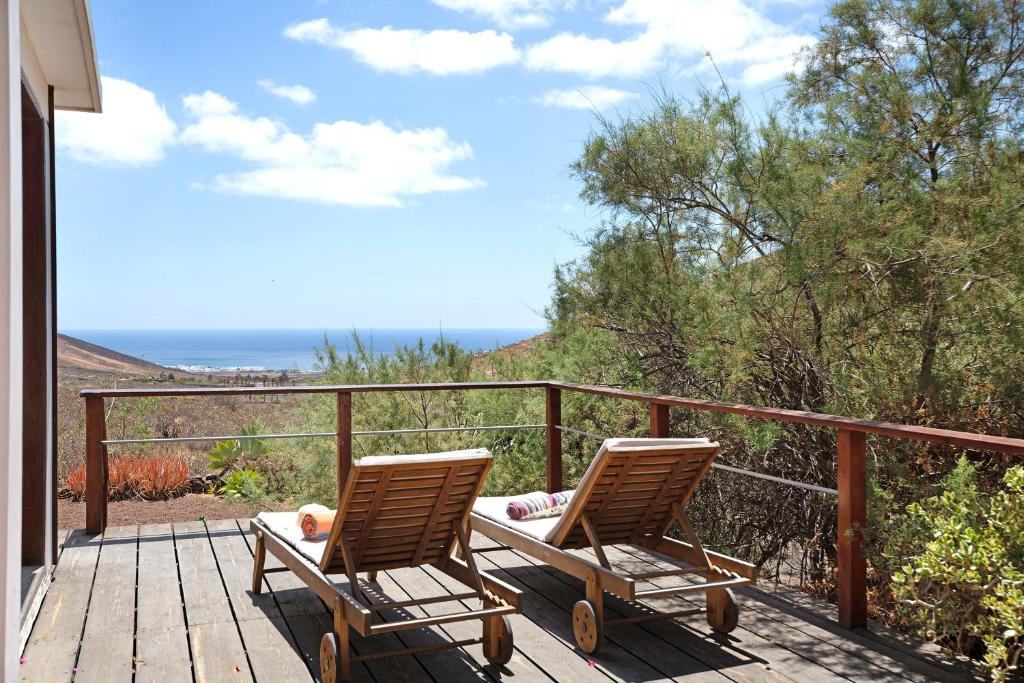 two chairs on a deck with a view of the ocean at Ecolodge Finca Chafariz in Tabayesco