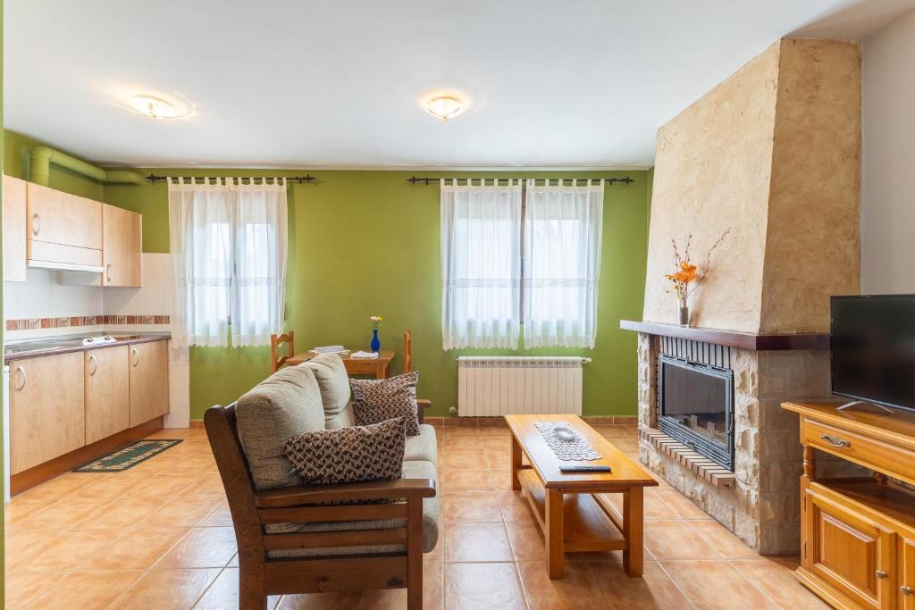 a living room with green walls and a fireplace at La Casa de Dafne Acebo in Santo Tomé del Puerto