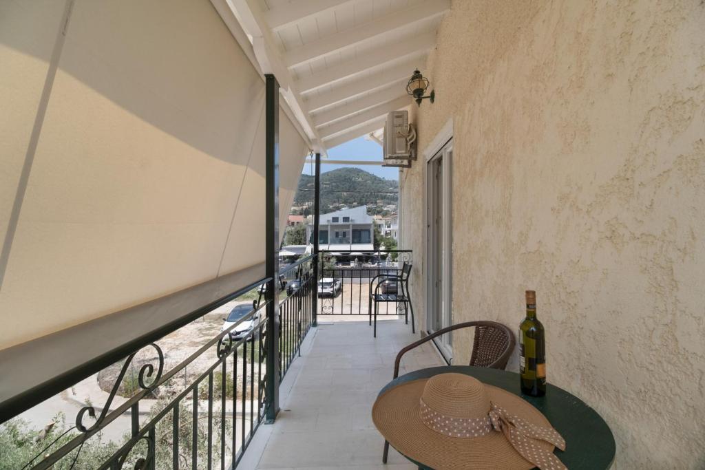 ein Balkon mit einem Tisch und einer Flasche Wein in der Unterkunft M5 room in Nikiana