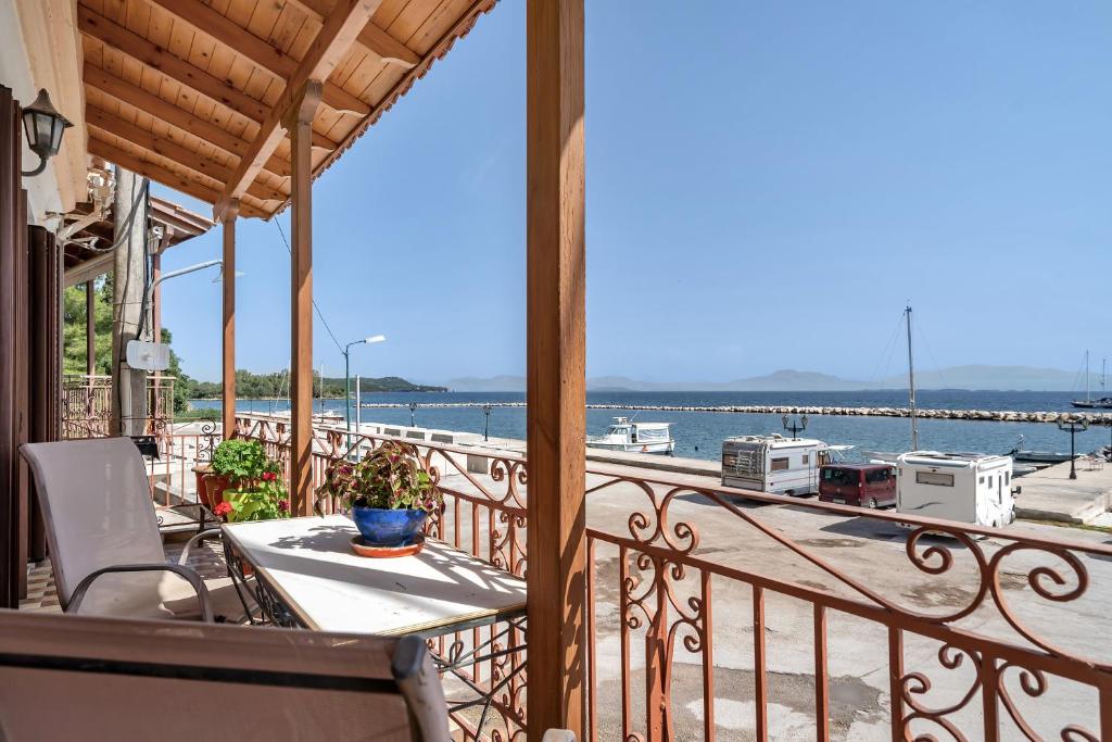 a balcony with a table and a view of the water at Barba Panais' House in Vonitsa