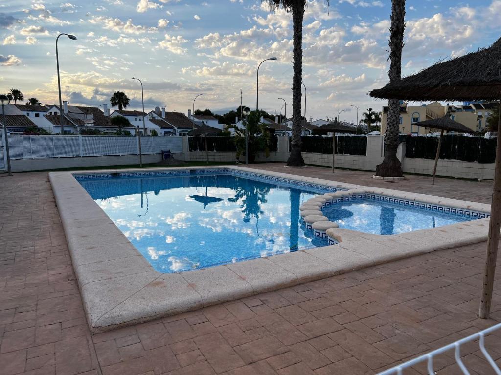 a swimming pool with blue water in a yard at Rodalia in El Verger