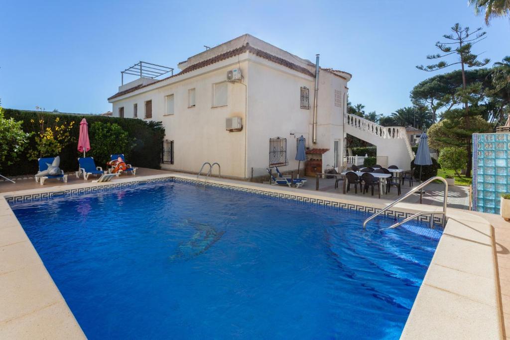 a large swimming pool in front of a house at 5 bedroom Villa private pool in Orihuela Costa