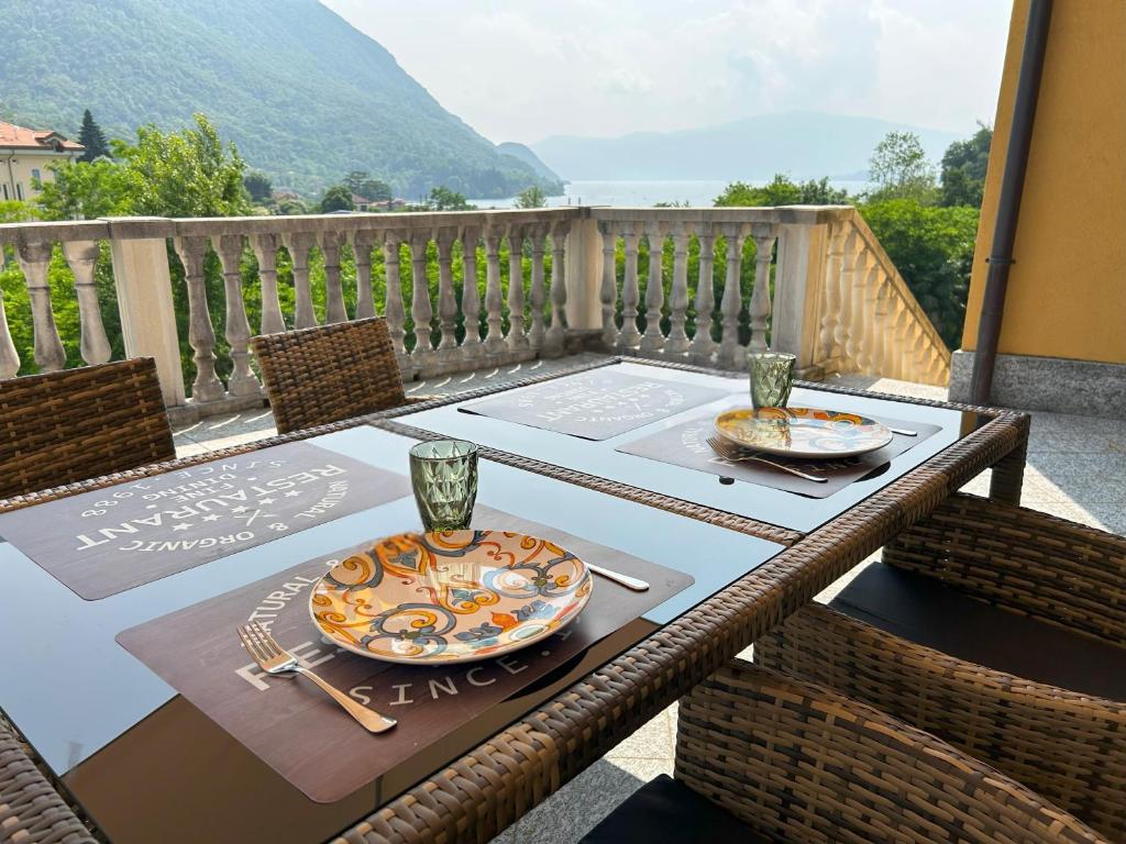a table with two plates of food on a balcony at Il sole di calde Lago maggiore 504 in Castelveccana