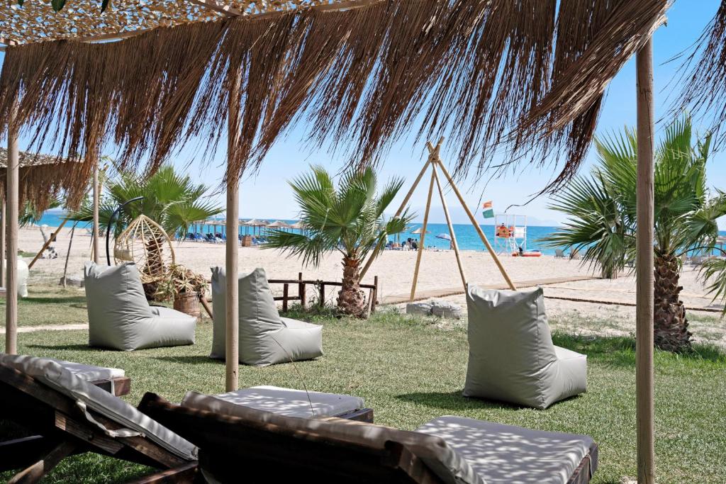 a beach with some chairs and a straw umbrella at Iguana studio 14 in Preveza