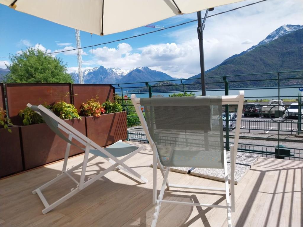 a table and a chair on a balcony with mountains at Vichi's nest in Pianello Del Lario