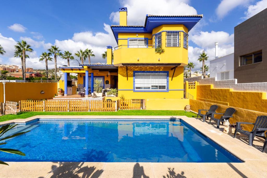 a yellow house with a swimming pool in front of it at Milestone House in Rincón de la Victoria