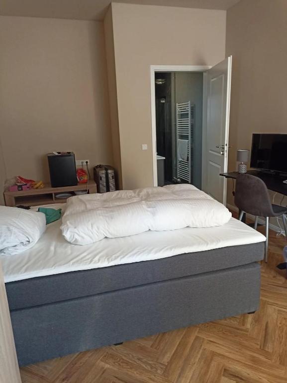 a bed in a room with a desk and a computer at Hotel zur Panke Wohnung 2 in Kolonie Röntgental