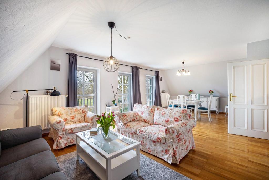 a living room with two couches and a table at Ferienwohnung Gestüt Kriseby in Lübeck