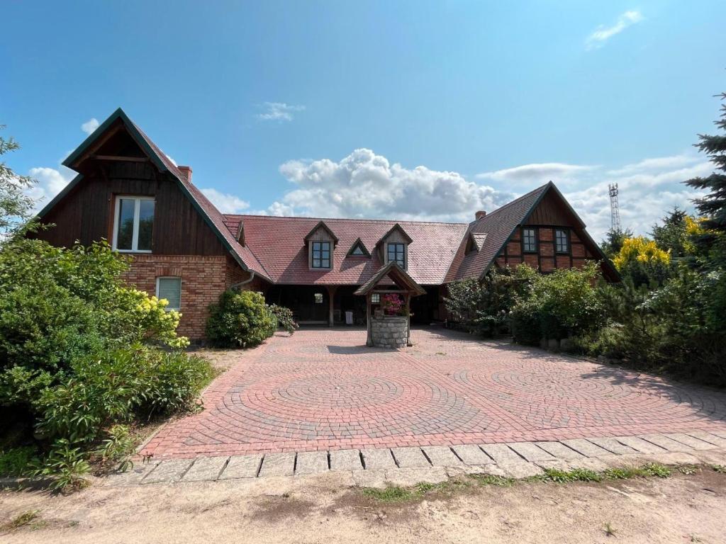 a large house with a brick driveway in front of it at Hof Verchen Nahe Kummerower See in Verchen