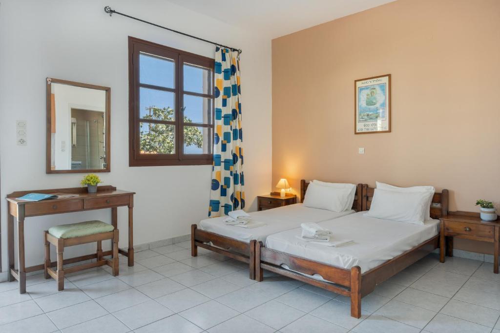 a bedroom with a bed and a table and a mirror at Frantzis studio 3 Nisyros in Páloi