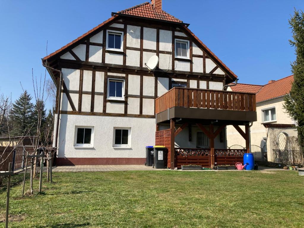 a house with a gambrel roof with a deck at Ferienwohnung Wie zu Hause in Ostritz