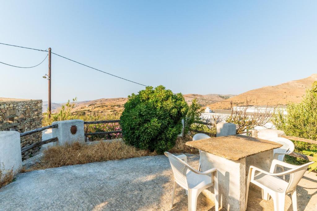 a patio with a table and chairs and a view at Kykladen White House in Koumáros