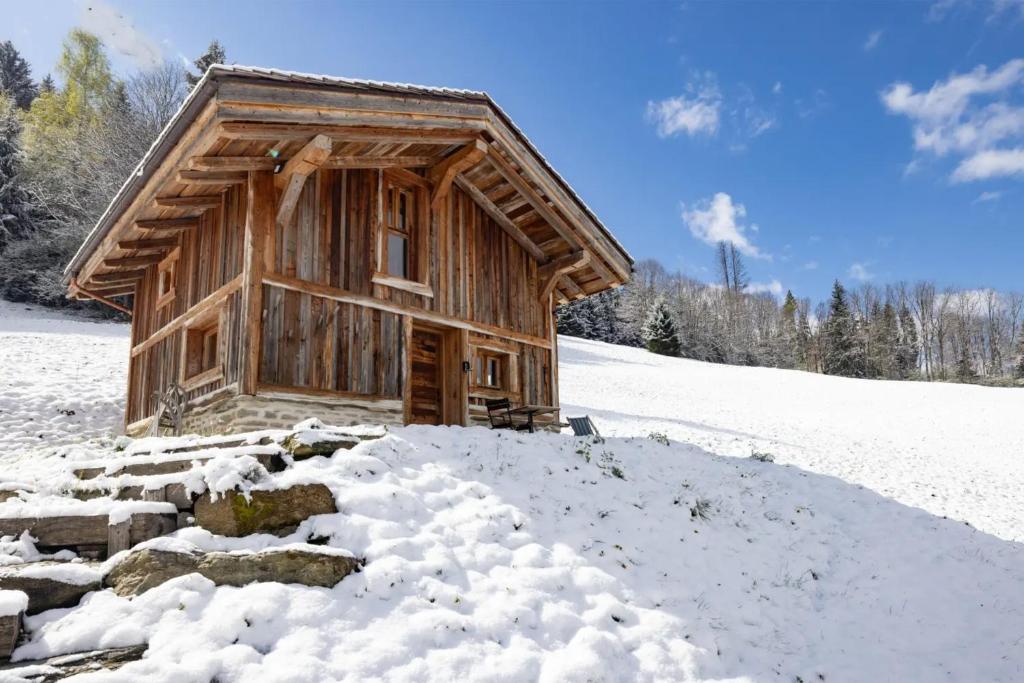 a log cabin in the snow with a pile of snow at Mazot des aravis in Combloux