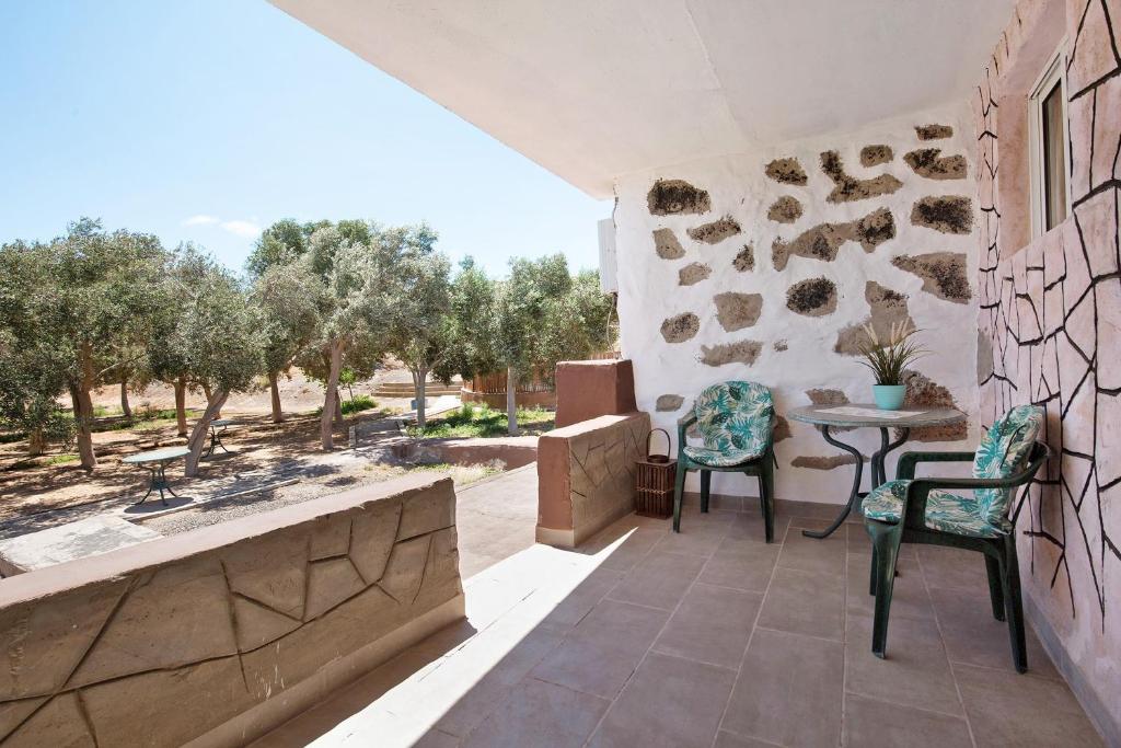 a patio with two chairs and a table on a building at Alma Eco-rústico Adults Only in El Charco
