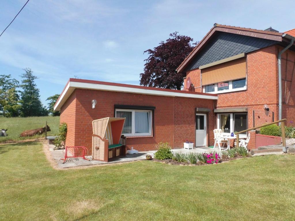 a brick house with a horse in the yard at Ferienwohnung Landhaus Loose in Schashagen