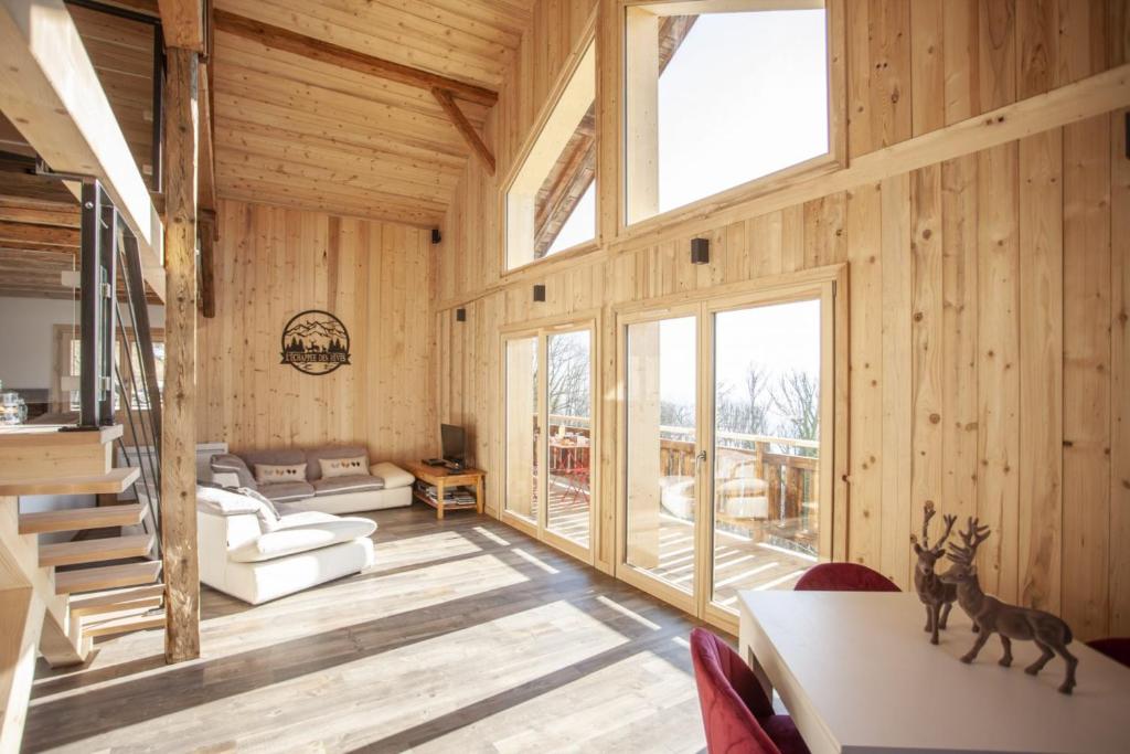 a living room with wooden walls and a large window at L'échappée des Rêves in Verchaix