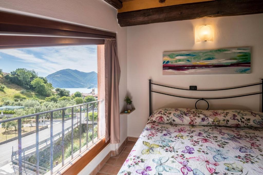 a bedroom with a bed and a large window at Mansarda con vista lago in Sulzano