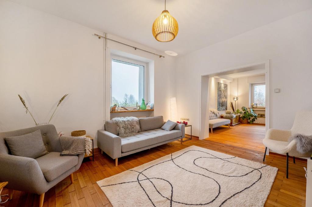 a living room with two couches and a rug at Alte Revierförsterei in Börfink
