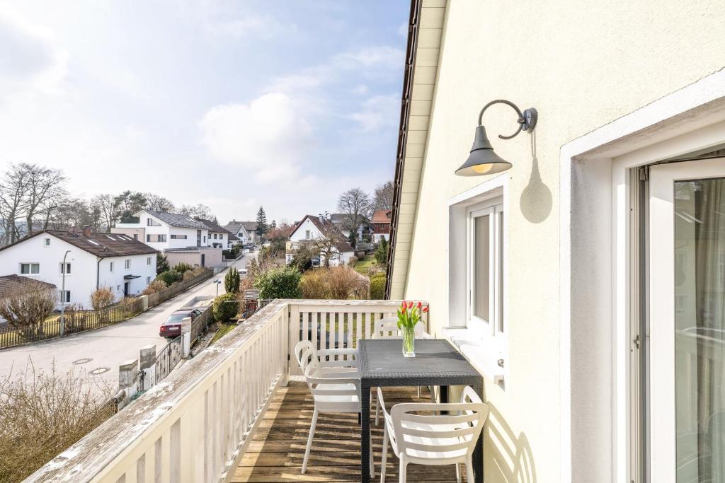 a balcony with a table and chairs and a view of a street at Ferienwohnung Bayerl in Kirchseeon