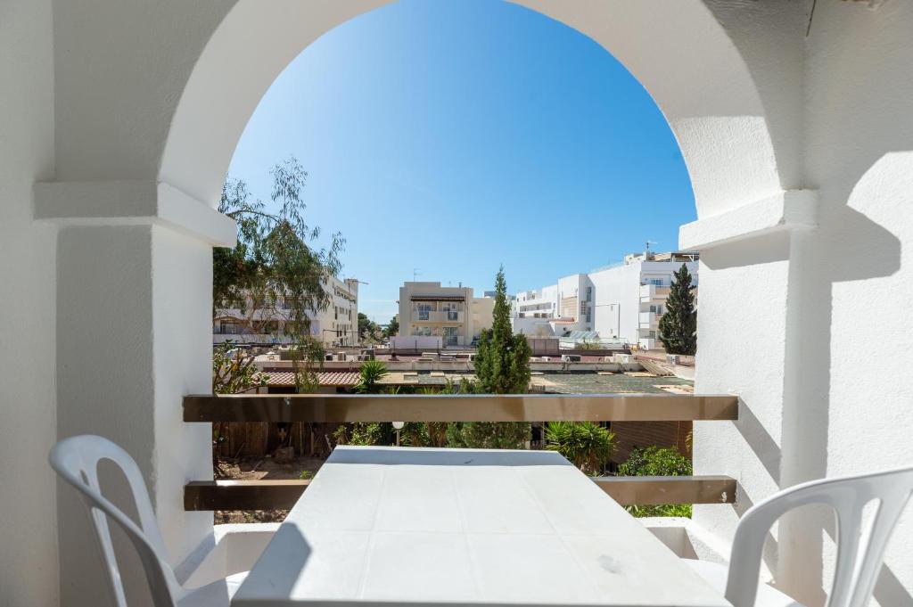 a white table and chairs on a balcony at Apartamento Isla Blanca in Es Pujols