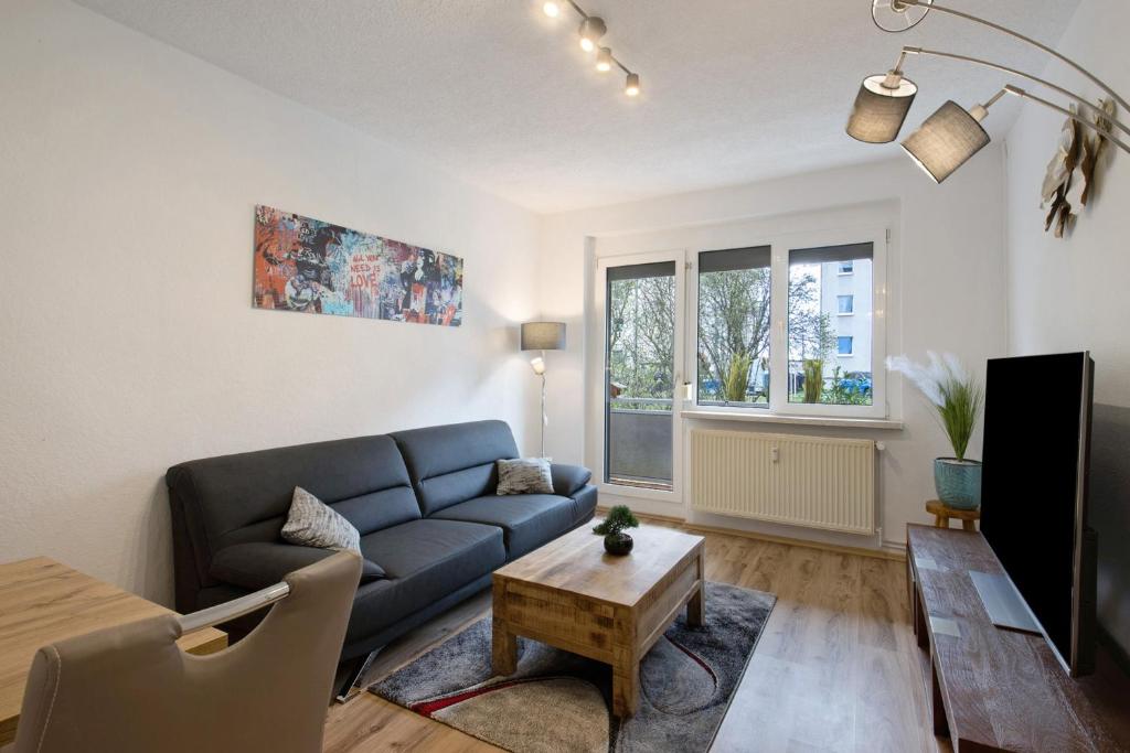 a living room with a blue couch and a table at Ferienwohnung San Marino 2 in Mücheln
