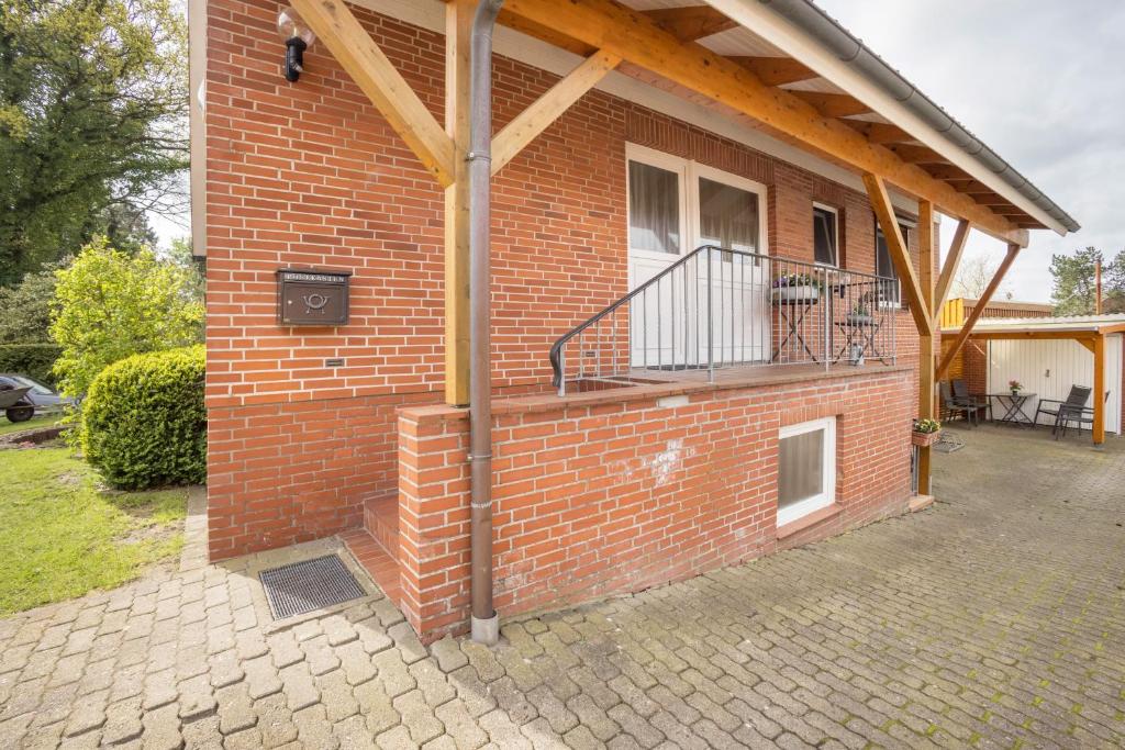 a brick house with a balcony on the side of it at Ferienwohnung Krempermoor 2 in Krempermoor