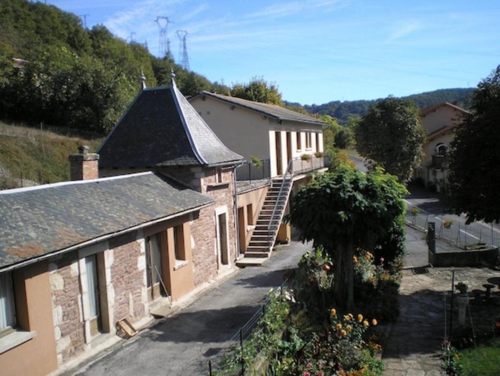an old brick building with a staircase in front of it at Gite La Combe de Melvieu in Viala-du-Tarn
