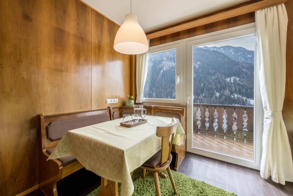 a dining room with a table and a large window at Apartment Sciadules in Ortisei