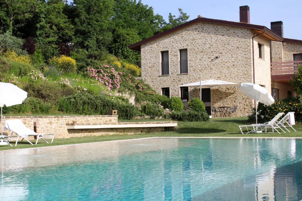 a house with a swimming pool in front of a building at Amazing Assisi in Assisi