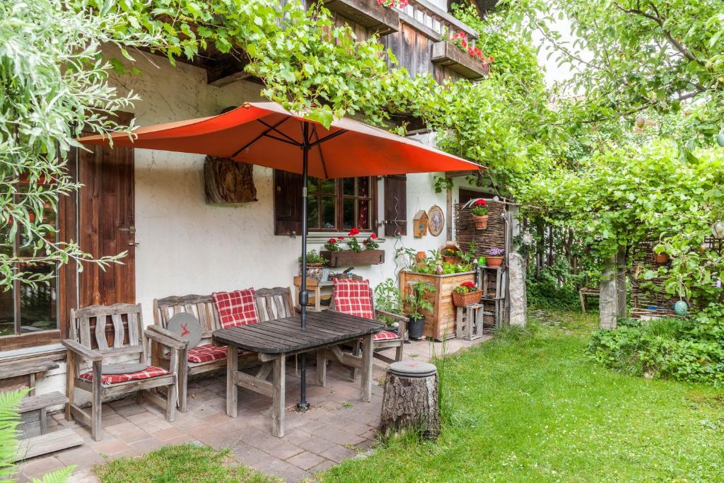 a table and chairs with an umbrella in a yard at Landhaus Lucia in Oberau