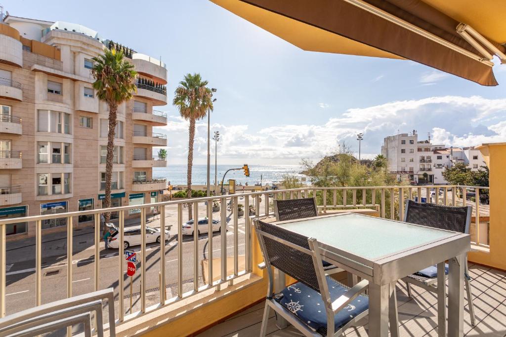 a balcony with a table and chairs and a view of a street at Apartamento Palomera Blanes in Blanes
