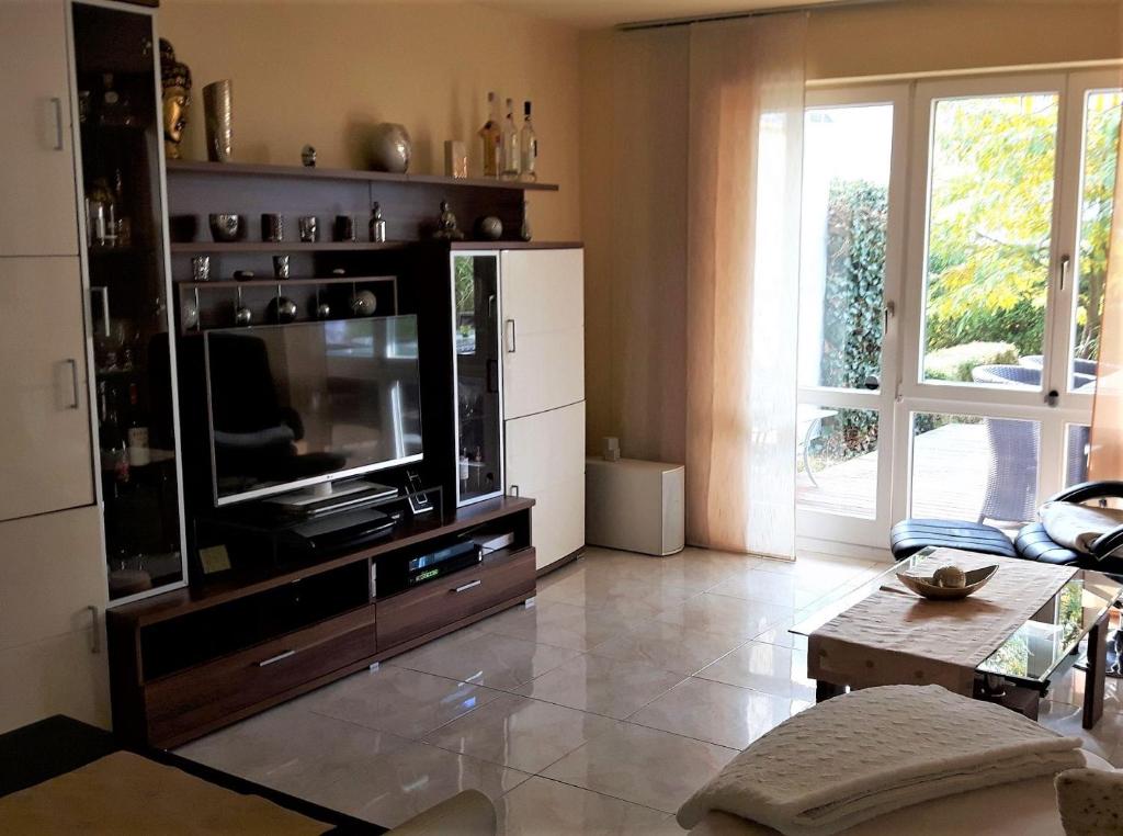 a living room with a tv on a entertainment center at Ferienwohnung Laura in Langenargen
