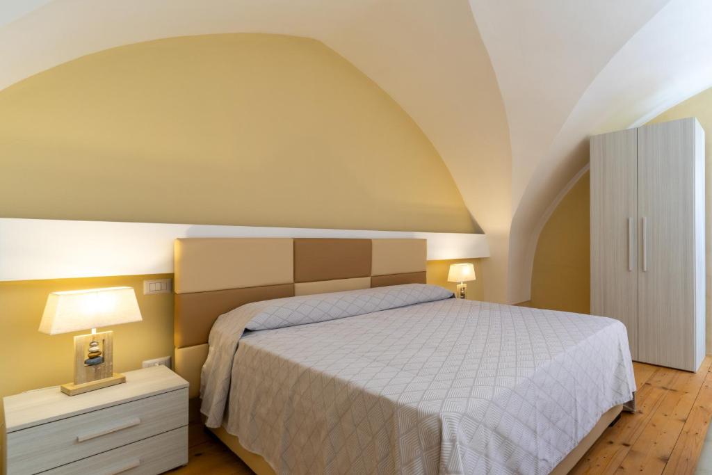 ein Schlafzimmer mit einem Bett mit einer weißen Tagesdecke in der Unterkunft La rimesa di Tittì - Anna in Alezio