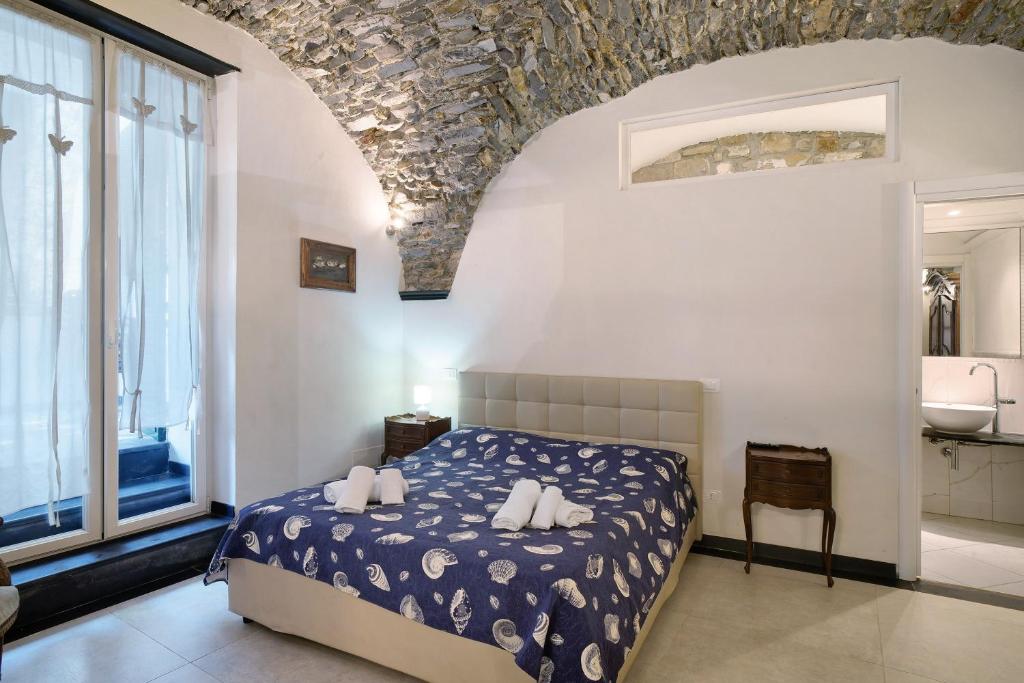 a bedroom with a bed and a large window at Inglese, borgo dei pescatori in Cervo
