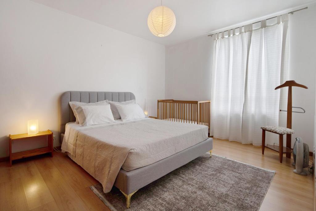a bedroom with a bed and a large window at São Roque Apartment in São Roque