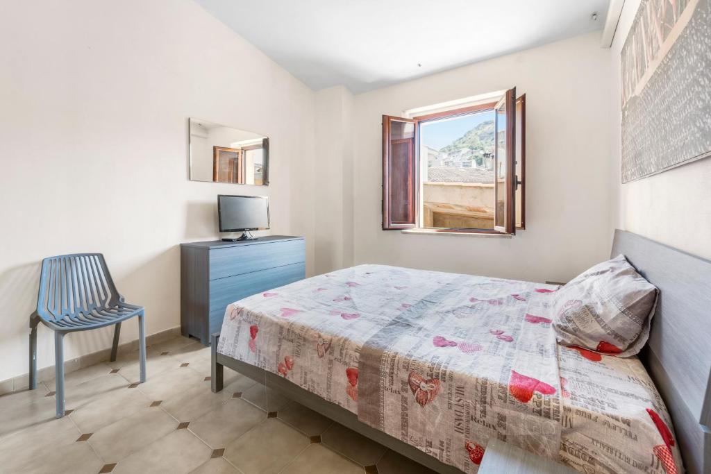 a bedroom with a bed and a chair and a window at Arbus Aventino Centrale in Arbus