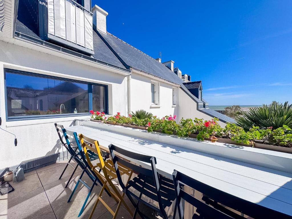 a wooden table and chairs on a patio at Les Embruns - Vue sur mer in Île-Tudy